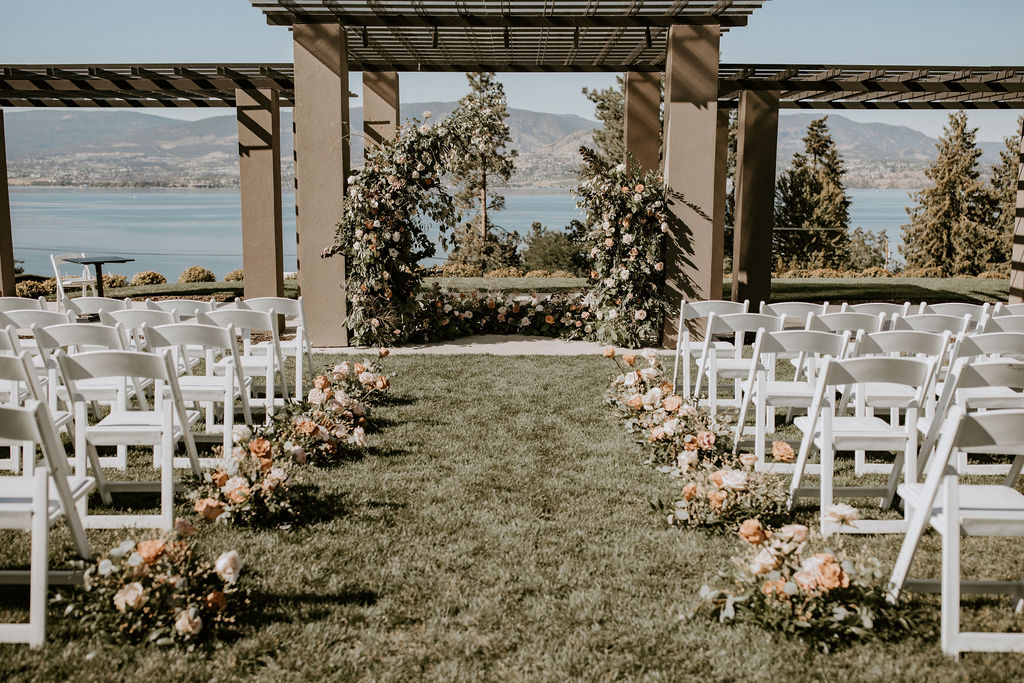 Wedding ceremony archway at CedarCreek Estate Winery with a floral lined aisle.