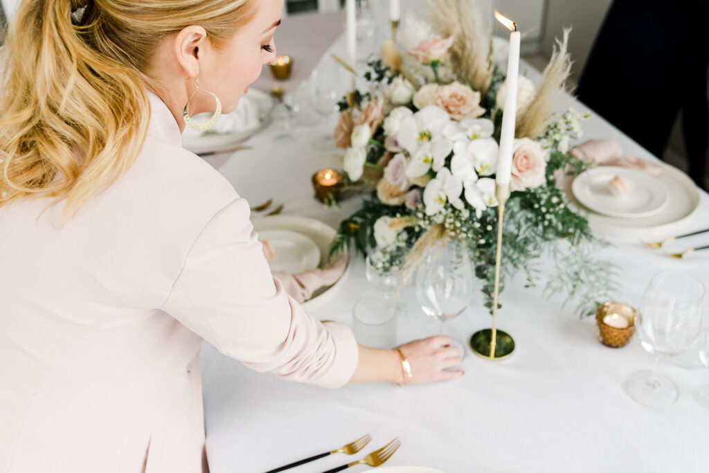 Ashley Davidson, CEO of The Modrn Company sets a white and blush coloured table for a wedding.