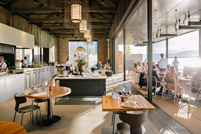 Tables, chairs and hanging chandeliers set the warm, chic interior design for Home Block Restaurant.